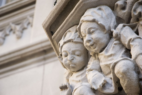 Two carved figures, one frowning and the other smiling.