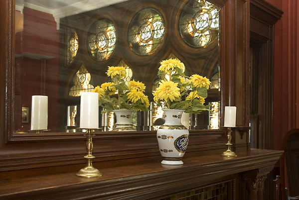 Light streams in on a vase in front of a mirror.