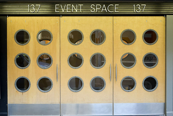 Three wooden doors, each with six circular glass windows.