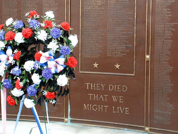 A wreath stands in front of an engraved list of fallen
soldiers.