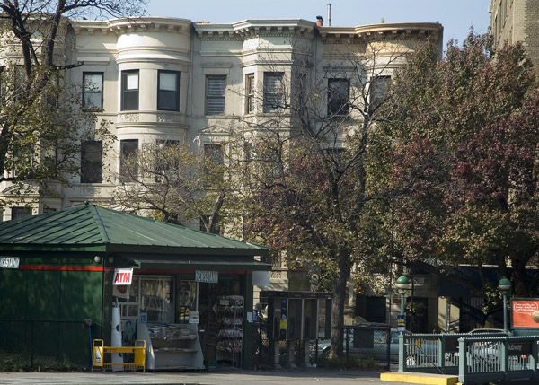 A row of apartment buildings sits beyond a
newsstand.