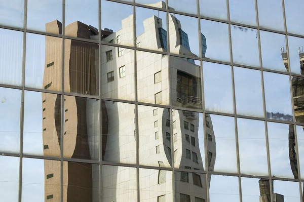 A modern building's reflection is broken into several
panes.