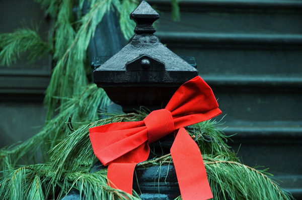 Green pine needles and a red ribbon decorate an
entrance.