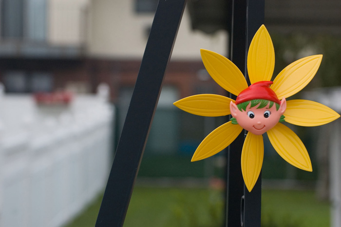 An elf smiles from the center of a plastic flower-shaped
pinwheel.