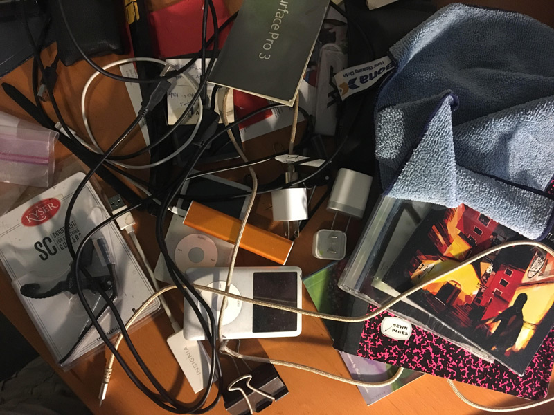 The picture shows a hodgepodge of items on a desk.