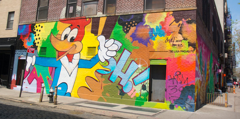 The photo shows a colorful mural featuring the cartoon character Woody Woodpecker.