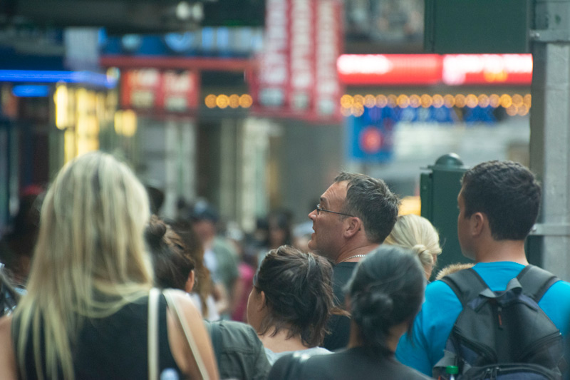 The photo focuses on a man in a crowd in New York's Times Square.