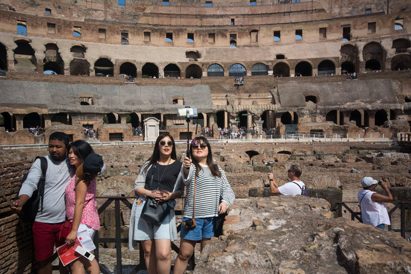 The photo shows couples taking selfies inside the Roman coliseum.