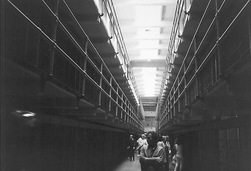 The photo shows tourists in Alcatraz prison, inspecting cells.